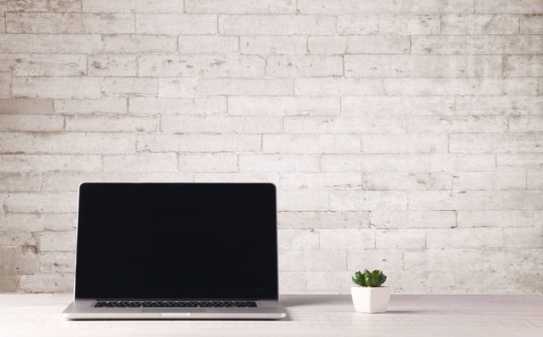 Business laptop with white brick wall - Фото, зображення