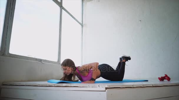 Nuori ja kaunis nainen tekee push-up lattialta kuntosalilla
 - Materiaali, video