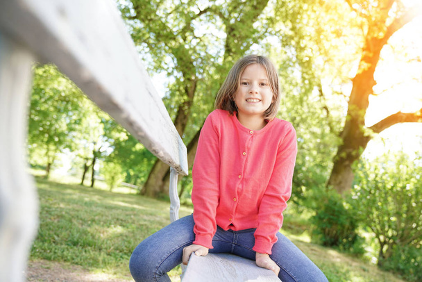  girl sitting on bench in park - Photo, Image