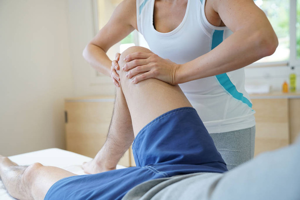 Physiotherapist massaging athlete  - Photo, Image