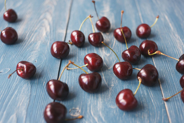 Berries of ripe cherries on a wooden background. - Photo, Image
