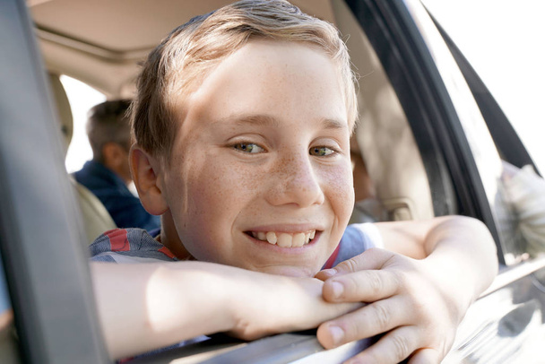  boy looking by car window - Фото, изображение