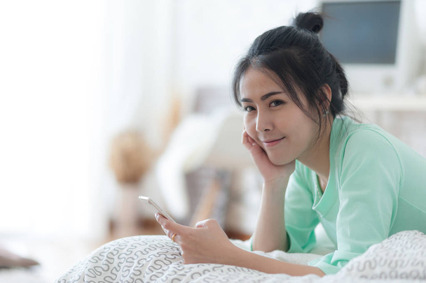 Młoda kobieta azjatyckich rozciąganie na łóżko po wake up - Zdjęcie, obraz