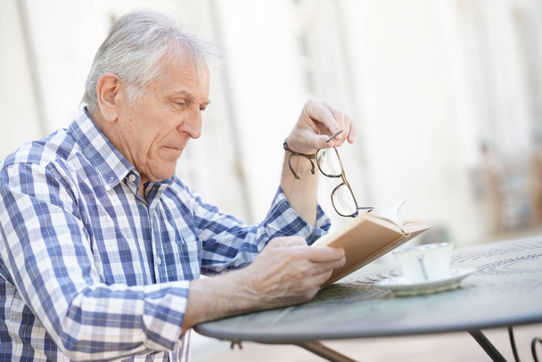 Elderly man reading book outside              - Foto, Imagem