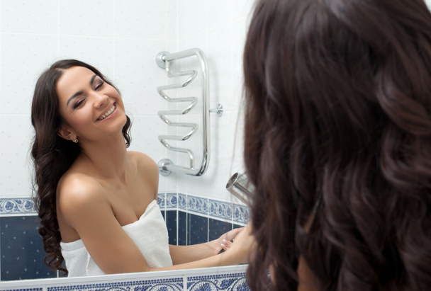 Pretty woman with hairdryer in bathroom - Фото, зображення