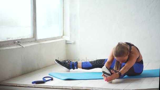 Nuori nainen harjoittaa jalkojen ompelua aktiivisen fyysisen harjoittelun jälkeen
 - Materiaali, video