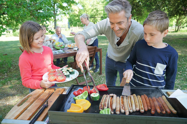 Father with kids preparing barbecue - Zdjęcie, obraz