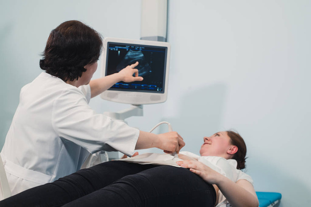 Лікар з використанням ультразвуку та скринінгу шлунку вагітної жінки
. - Фото, зображення