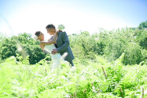 Bride and groom in countryside - Фото, изображение