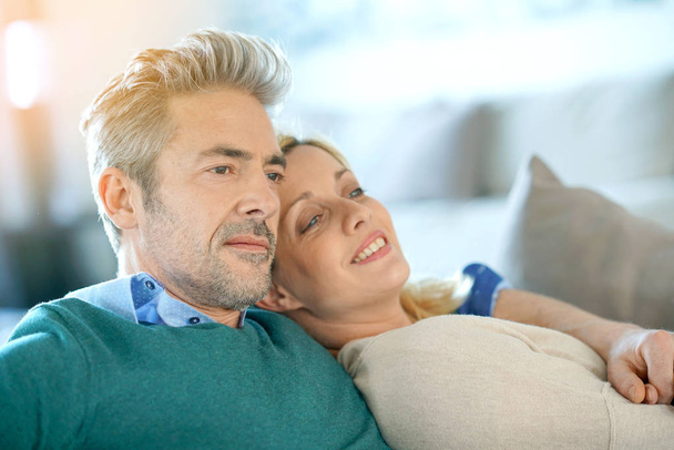 couple relaxing together in sofa - Foto, afbeelding