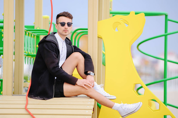 giovane uomo alla moda prende nel parco giochi
 - Foto, immagini
