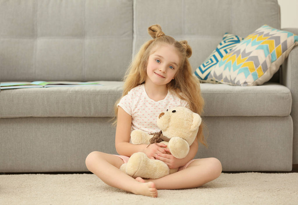 Small girl holding teddy bear  - Фото, изображение