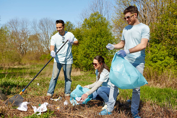 volunteers with garbage bags cleaning park area - Foto, Bild