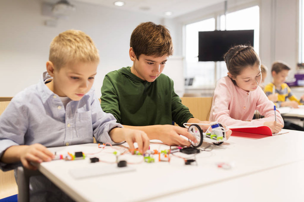 happy children building robots at robotics school - Foto, imagen