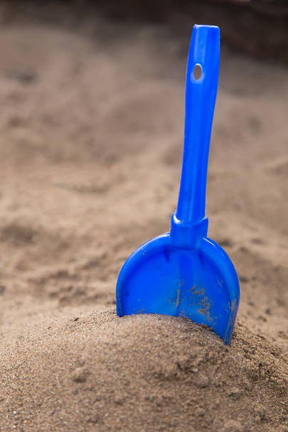 Yellow children's shovel in the sandbox close up - Fotoğraf, Görsel