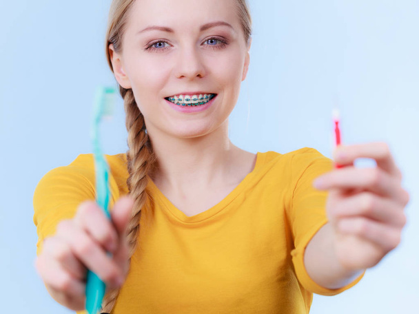 Frau lächelt beim Zähneputzen mit Zahnspange - Foto, Bild