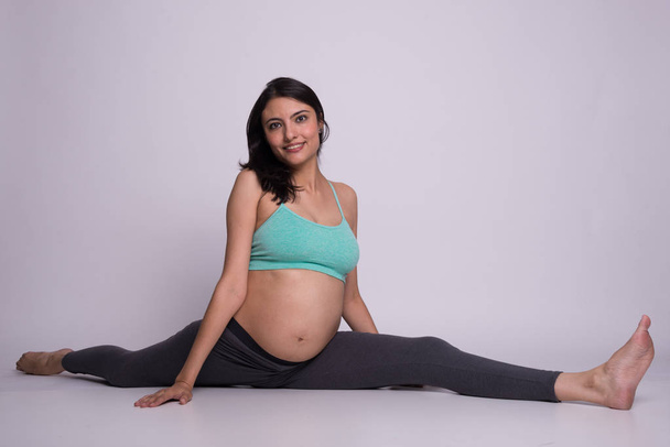 Kobieta w ciąży robi split - Zdjęcie, obraz