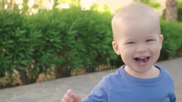 Ritratto di un simpatico allegro ragazzo biondo europeo che si gode una passeggiata in un bellissimo parco estivo, slow mo
 - Filmati, video