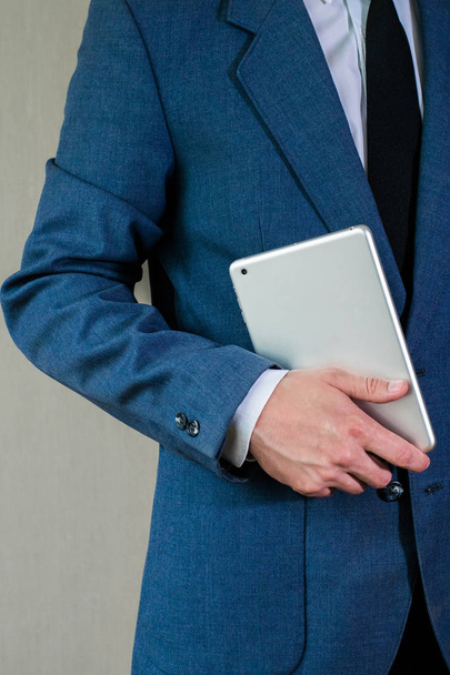 Бізнесмен в куртці тримає планшет
 - Фото, зображення