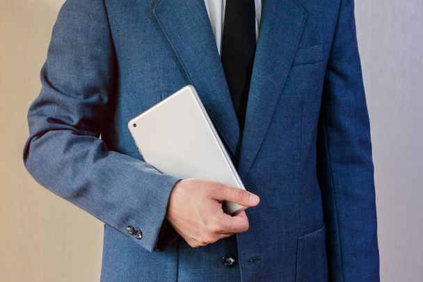 Businessman in a jacket holding a tablet - Foto, afbeelding