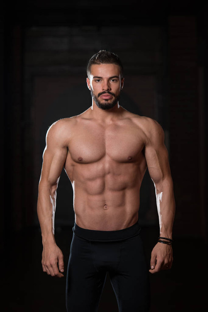 Handsome Muscular Model Flexing Muscles In Gym - 写真・画像