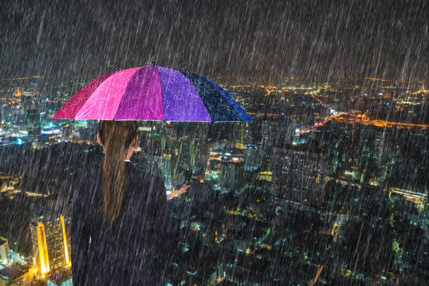 business woman holding multicolored umbrella with falling rain a - Photo, Image
