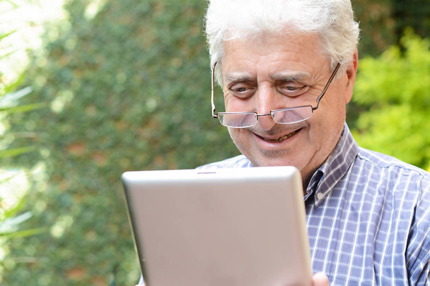 Old man using digital tablet. - Foto, imagen