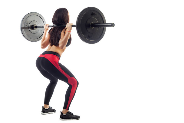 Woman doing squat  with a barbell - Foto, immagini