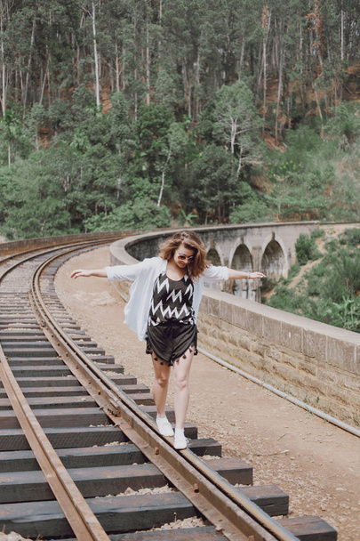 Girl walking on rails in Asian countryside - Fotoğraf, Görsel