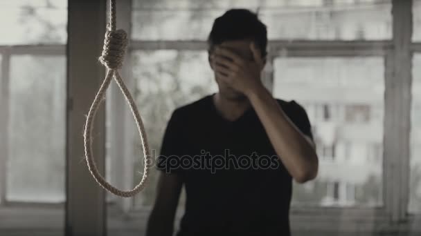 Öngyilkosság. Depressziós ember sír a háttérben a hurok a nyaka. - Felvétel, videó