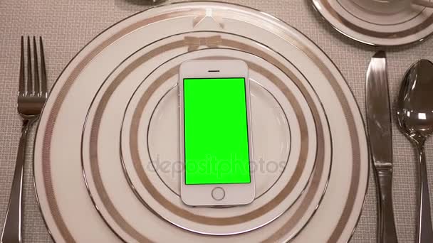 Movimiento de la vajilla de visualización y teléfono de pantalla verde en la placa
  - Metraje, vídeo