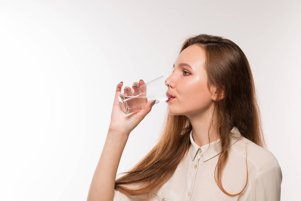Молодая девушка пьет чистую воду из стакана
 - Фото, изображение