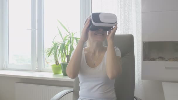 Heureuse femme souriante qui essaie le casque de réalité virtuelle et l'enlève. Images tournées en 4K
 - Séquence, vidéo