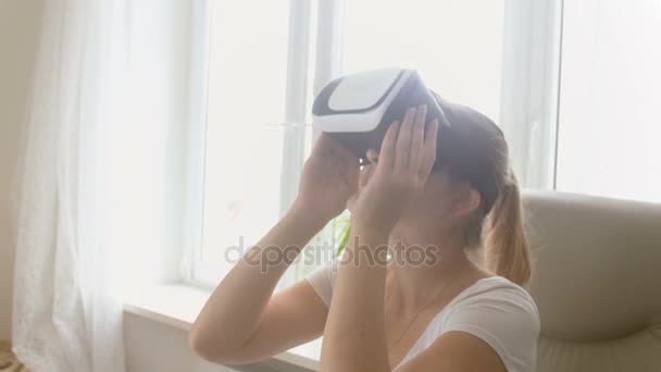 Πορτρέτο της νεαρής γυναίκας που παρακολουθείτε βίντεο 360 σε σετ κεφαλής εικονικής πραγματικότητας στο σπίτι. Ντοκουμέντα στο 4k - Πλάνα, βίντεο