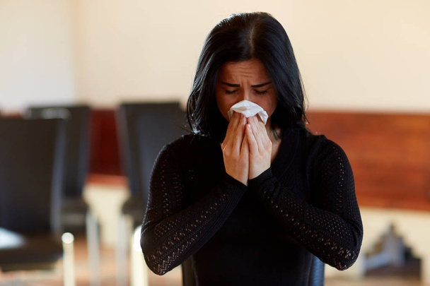 crying woman with wipe at funeral in church - Фото, зображення