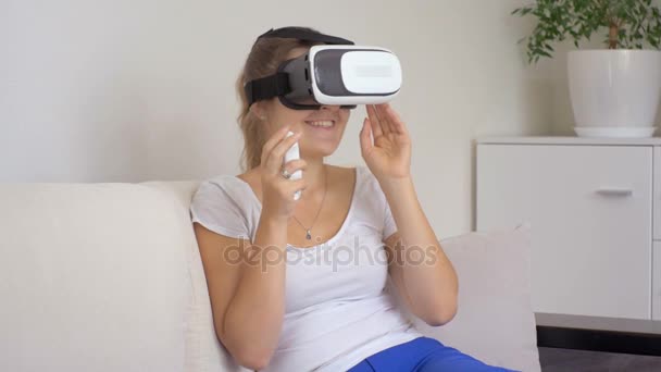 Νεαρή γυναίκα που φοράει ακουστικά εικονική πραγματικότητα βλέποντας ταινία 3d και χρησιμοποιώντας έλεγχο joystick. Ντοκουμέντα στο 4k - Πλάνα, βίντεο