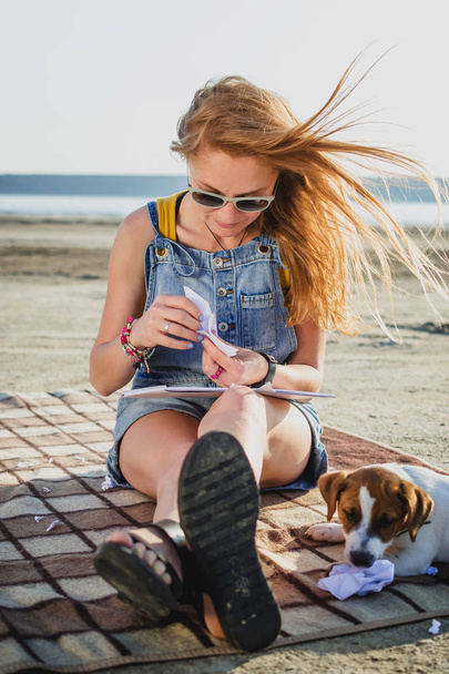 Young stylish hipster girl with origami on the beach - Photo, image