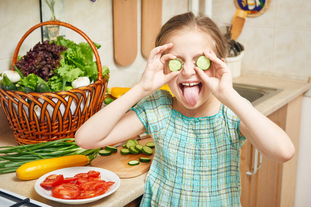 menina no interior da cozinha, legumes e frutas frescas em cesta, conceito de nutrição saudável
 - Foto, Imagem