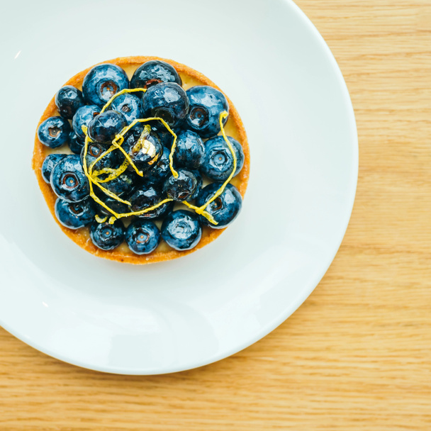 Słodki deser z blueberry tart w biały talerz - Zdjęcie, obraz