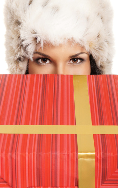 Young and beautiful woman holding a nice Christmas present over white background - Foto, afbeelding