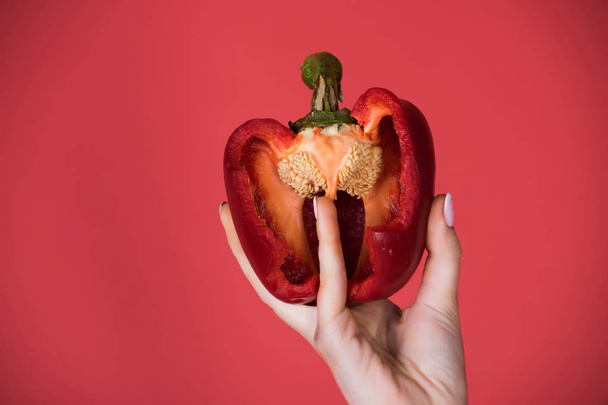 half of bell pepper in hand of woman, heart - Photo, Image
