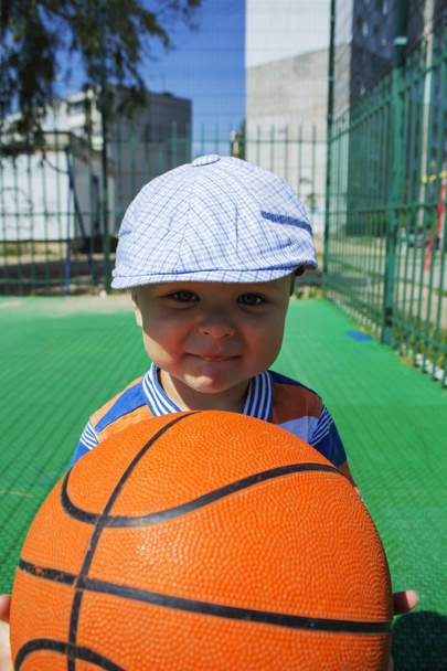 un niño sostiene una pelota de baloncesto
 - Foto, imagen