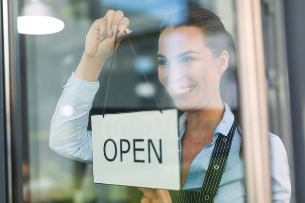 Woman holding open sign in cafe - Foto, imagen