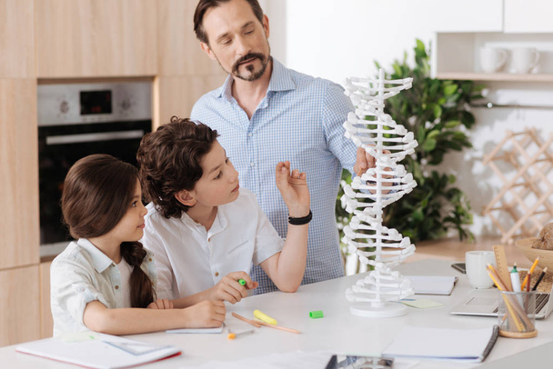 Jovem pai explicando a noção de DNA para seus filhos
 - Foto, Imagem
