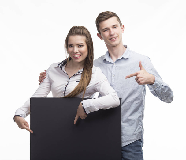 Young happy couple showing presentation pointing on placard over - Zdjęcie, obraz