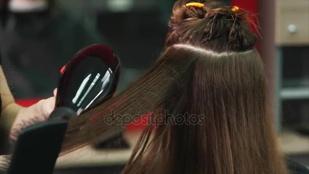 κοντινό πλάνο της διαδικασίας του στεγνώματος μαλλιών με πιστολάκι για τα μαλλιά και χτένα - Πλάνα, βίντεο