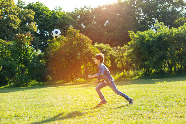 Ambitieuze energetische kind loopt na zijn bal - Foto, afbeelding