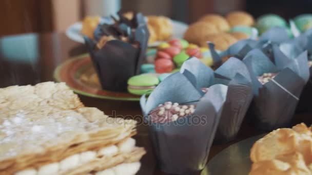 Sokerijauhe täynnä kerroksellinen kakku pöydällä paljon leivonnaisia
 - Materiaali, video