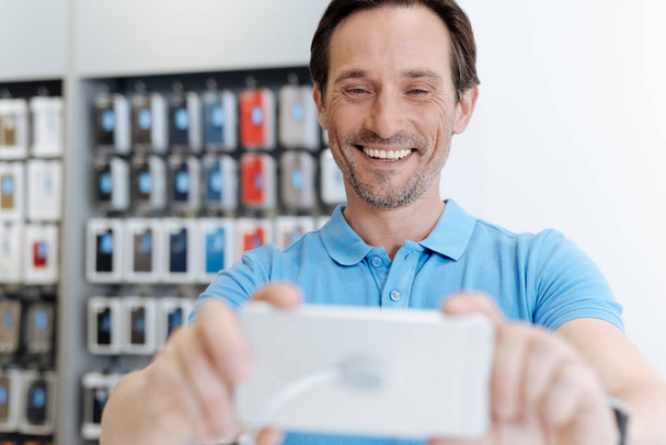 Radiant adult shopper taking selfie with template smartphone - Foto, Imagem