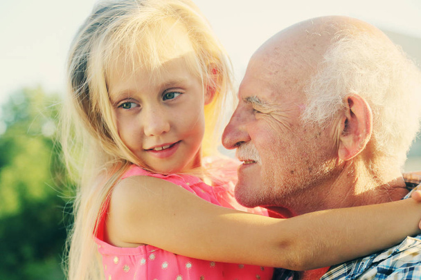 Grandfather holding granddaughter - Photo, Image